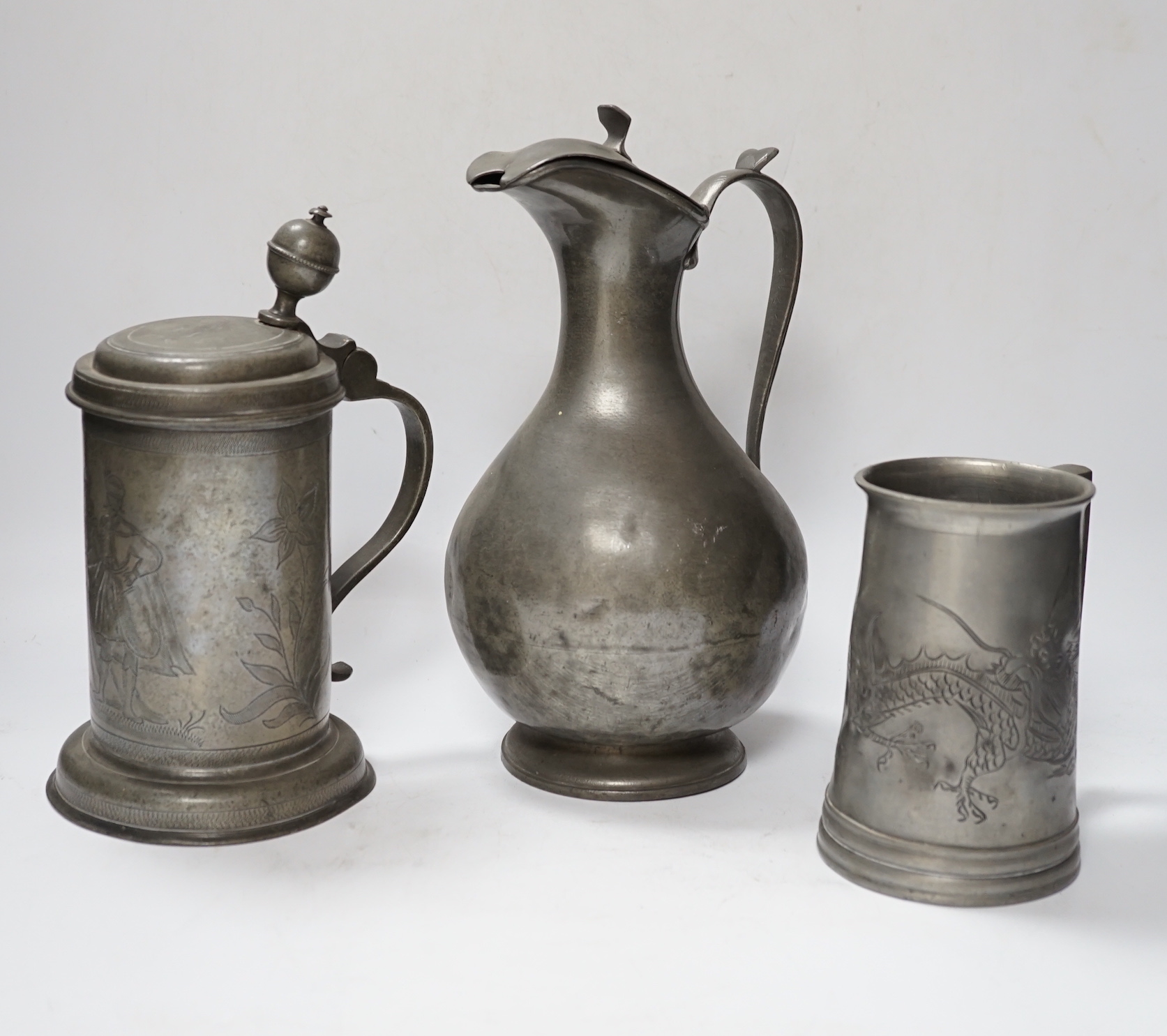 Six pewter items including an 18th-century Continental wriggle work tankard, two more tankards and two lidded jugs and a lead mounted figure of a Medieval king, lead figure 35cm high